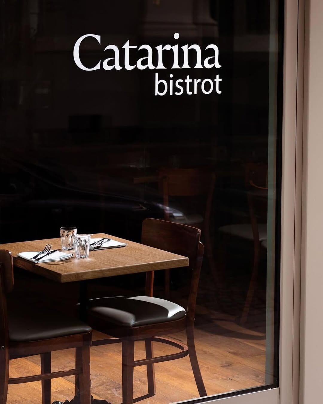 Vetrina di Catarina Bistrot con tavolo apparecchiato visibile dall&rsquo;esterno