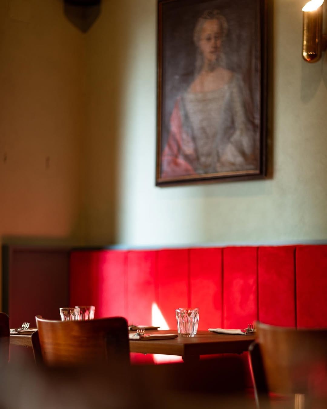 Atmosfera intima nella sala di Catarina Bistrot Sala interna di Catarina Bistrot con tavoli apparecchiati e divanetti rossi