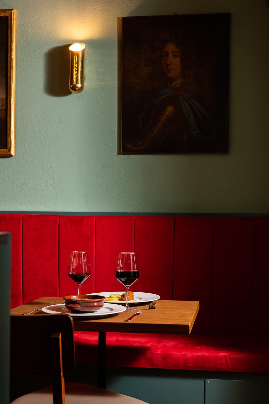 Tavolo apparecchiato per la cena – Catarina Bistrot Torino Tavolo apparecchiato con piatti e calici di vino nella sala di Catarina Bistrot, ristorante nel centro di Torino