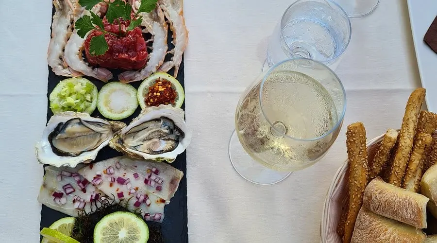 Antipasto di crudi con ostriche e calice di vino bianco del ristorante Sicilia in Bocca, Catania