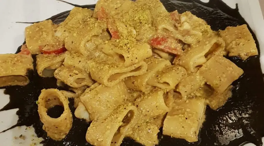 Piatto di pasta con tonno e nero di calamari, una ricetta mediterranea con un sapore unico e un condimento dal colore intenso.