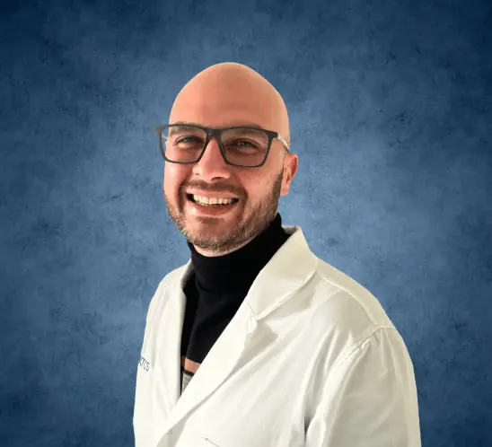 Foto del Dr. Michele Malaguarnera, dermatologo specializzato, durante una consulenza con un paziente in studio medico.