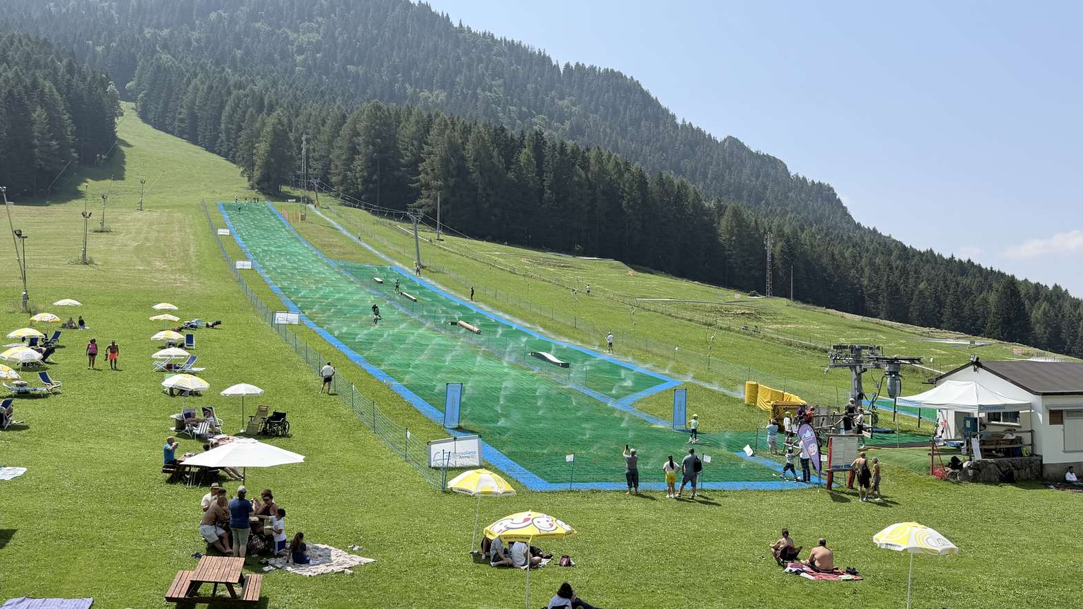 Panoramic view of Presolana Ski Arena 365 with skiers on the artificial ski slope Panoramic view of Presolana Ski Arena 365 with skiers on the artificial ski slope