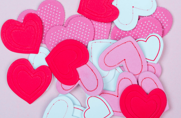 Cuori di carta differenti sul tavolo, rosso, rosa, bianco, ricami, pois pallini, vista frontale; ti amo e ti voglio bene in inglese