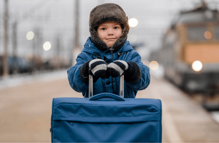 Inverno, bambino colbacco, stazione treno, valigia blu, partenza, viaggio e valigia; 20 frasi in inglese da utili quando si viaggia all’estero con i bambini