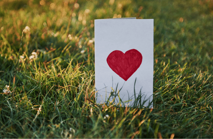 Bigliettino bianco d'amore con cuore rosso sul prato verde; amore; san valentino; 40 frasi d'amore in inglese