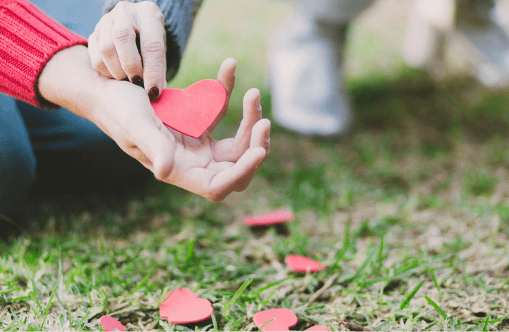 coppia innamorata con mani sul prato verde, amore, san valentino; 40 frasi d'amore in inglese