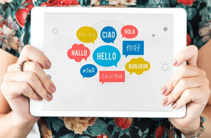 Tablet con parole di varie lingue, hello, ciao, hola, bonjour; vista frontale; Cos'è il bilinguismo consecutivo e simultaneo