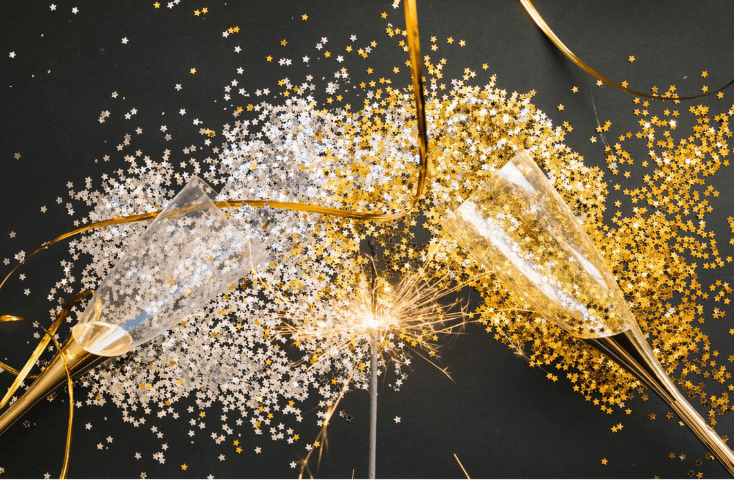 Bicchieri flute per brindisi; fuochi artificio; stellina, stelline oro e argento; cin cin fondo nero; vista dallìalto; come si dice Capodano in inglese