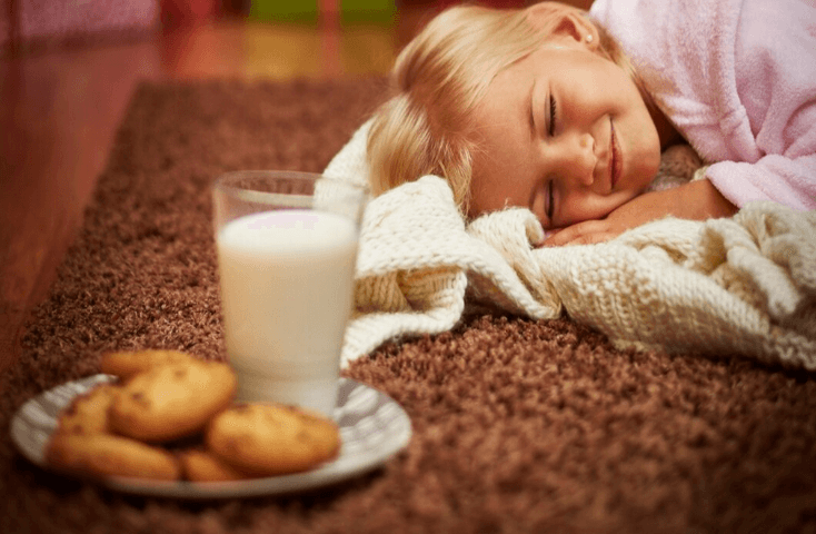 Bambiina dorme su tappeto mentre aspetta Babbo Natale, con piatti di biscotti e bicchiere di latte per le renne, Poesie di Natale in inglese tradotte in italiano