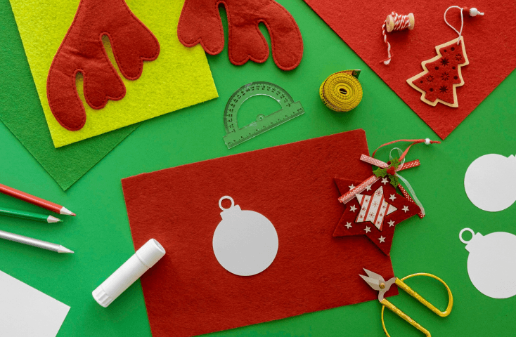 elementi per regali di natale e addobbi fai-da-te; vista dall'alto; renna di carta, cartoncino rosso, stella, forbici gialle, pennarello, metro a nastro, pennarello; lavoretti di natale per bambini in inglese
