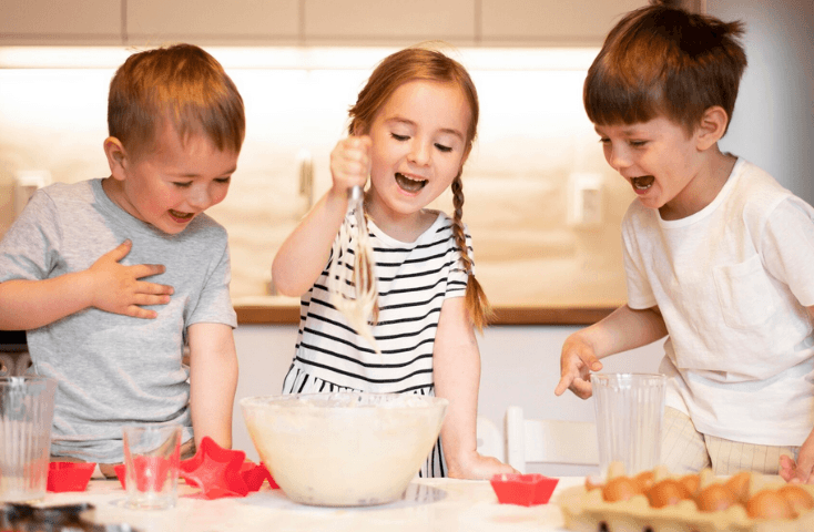 fratelli e sorella che si divertono a cucinare con impasto nella ciotola e frusta in cucina, uova e farina, quattro ricette dolci da preparare con i bambini