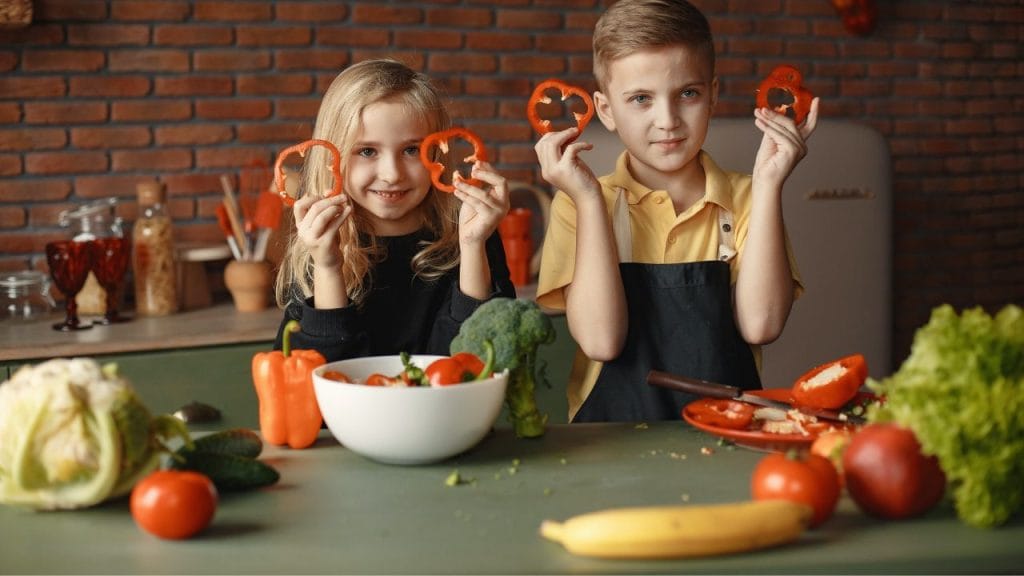 Bambini in cucina circondati da verdure, nomi di cibi e bevande in inglese