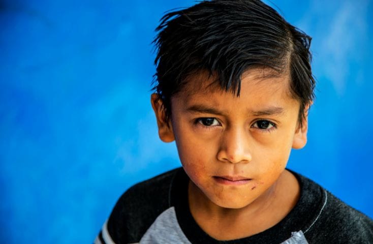 bambino malinconico su sfondo azzurro, come si dice azzurro in inglese
