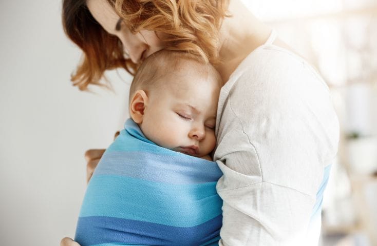 mamma con in braccio bimbo in fasce che si èappena addormentato, ninne nanne in inglese