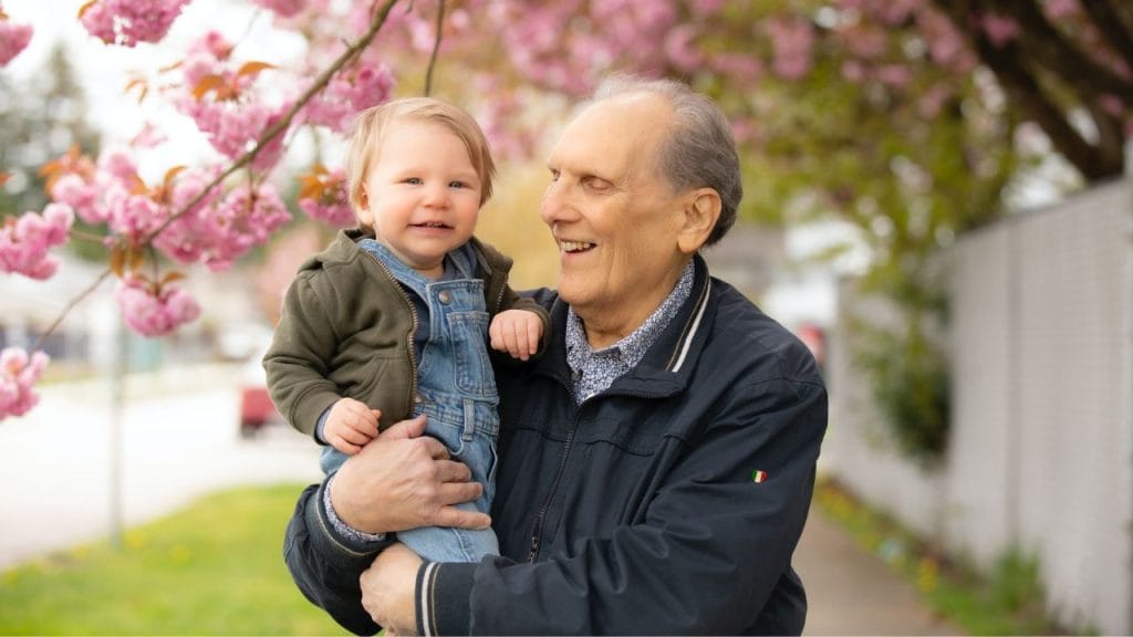 Nonno sorridente con in braccio il nipotino, come si dice nonno in inglese