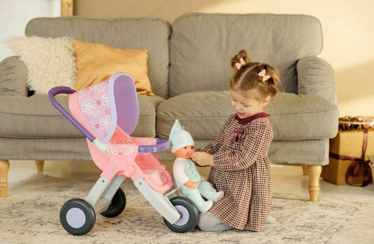 bambina che gioca con un bambolotto e un passeggio giocattolo, nomi dei giocattoli in inglese