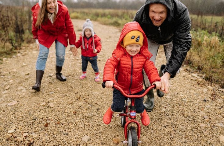 bambina in bicicletta sostenuta dal papà e con mamma e fratellino che la incitano, bike, 50 parole che cominciano con la B in inglese