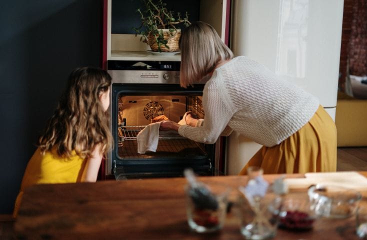 nonna con la nipote che cuoce biscotti nel forno, come si dice caldo in inglese