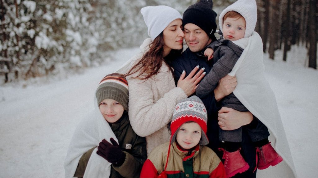 Famiglia con genitori e tre figli fuori al freddo ben coperti, come si dice freddo in inglese
