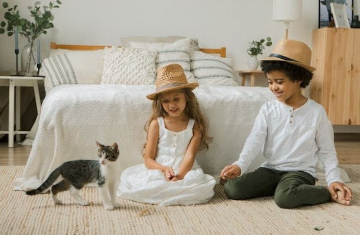 bambini seduti per terra in cameretta mentre guardano un gattino, versi degli animali in inglese