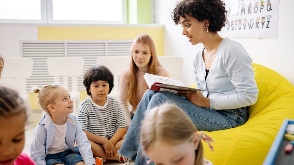 Donna che parla ai bambini spiegando loro qualcosa, phrasal verbs in inglese