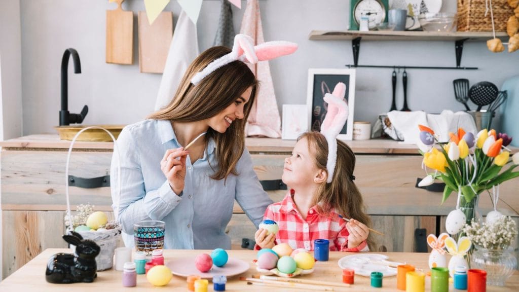 mamma e figlia con le orecchie da coniglio decorano le uova per Pasqua, poesie e filestrocche pasquali in inglese per bambini