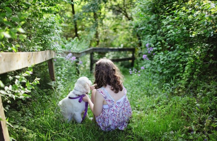 bambina nel bosco accanto a un cucciolo bianco, come si dice cane in inglese