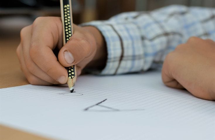 mano di un bambino che scrive la lettera a,5 canzoncine per imparare l'alfabeto in inglese