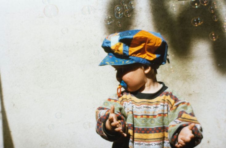 bombo che gioca con in bocca il ciuccio, come si dice ciuccio in inglese