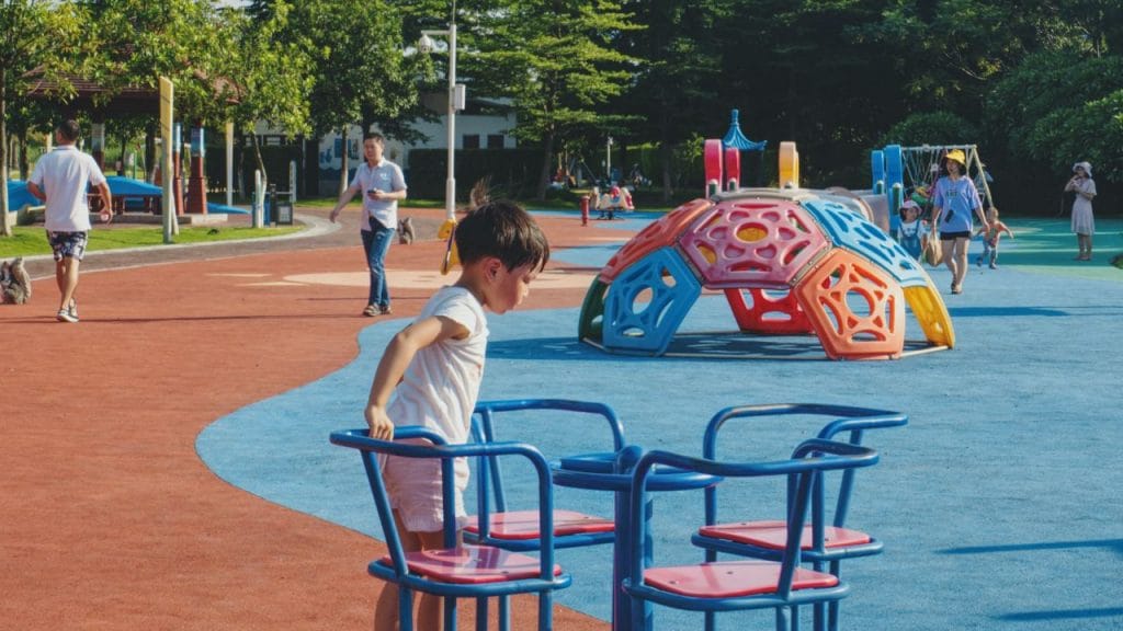 bambino su una giostrina al parco giochi, 5 frasi utili in inglese da usare coi bambini al parco giochi