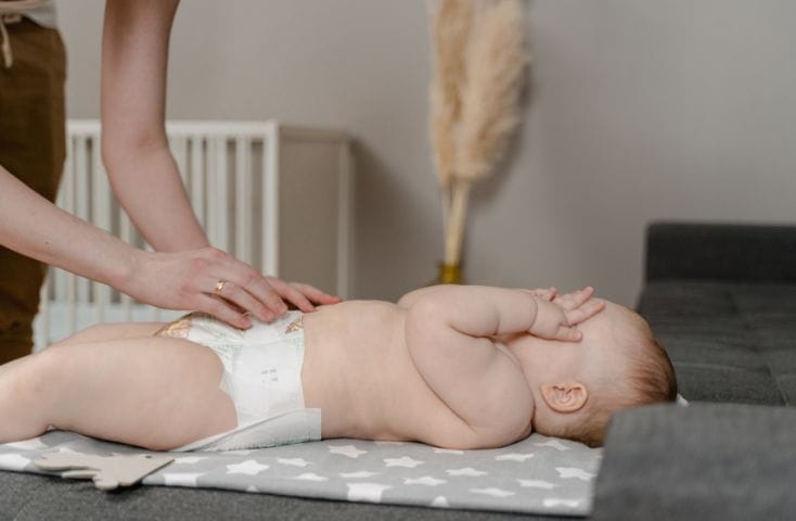 bimbo sul fascaitoio mentre la mamma gli cambia il pannolino,come si dice pannolino in inglese