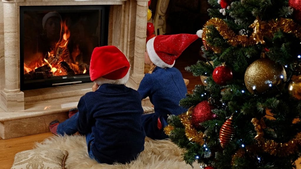 bambini che attendono Babbo Natale davanti al camino, come si dice Vigilia di Natale in inglese