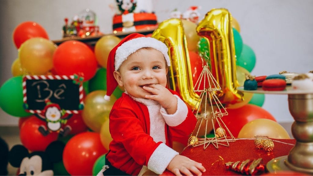 bimbo vestito da Babbo Natale contrornato da giochi che ascolta filestrocche di Natale
