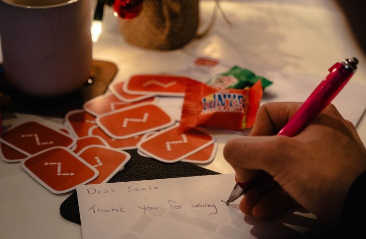 Mano che scrive letterina a Babbo Natale