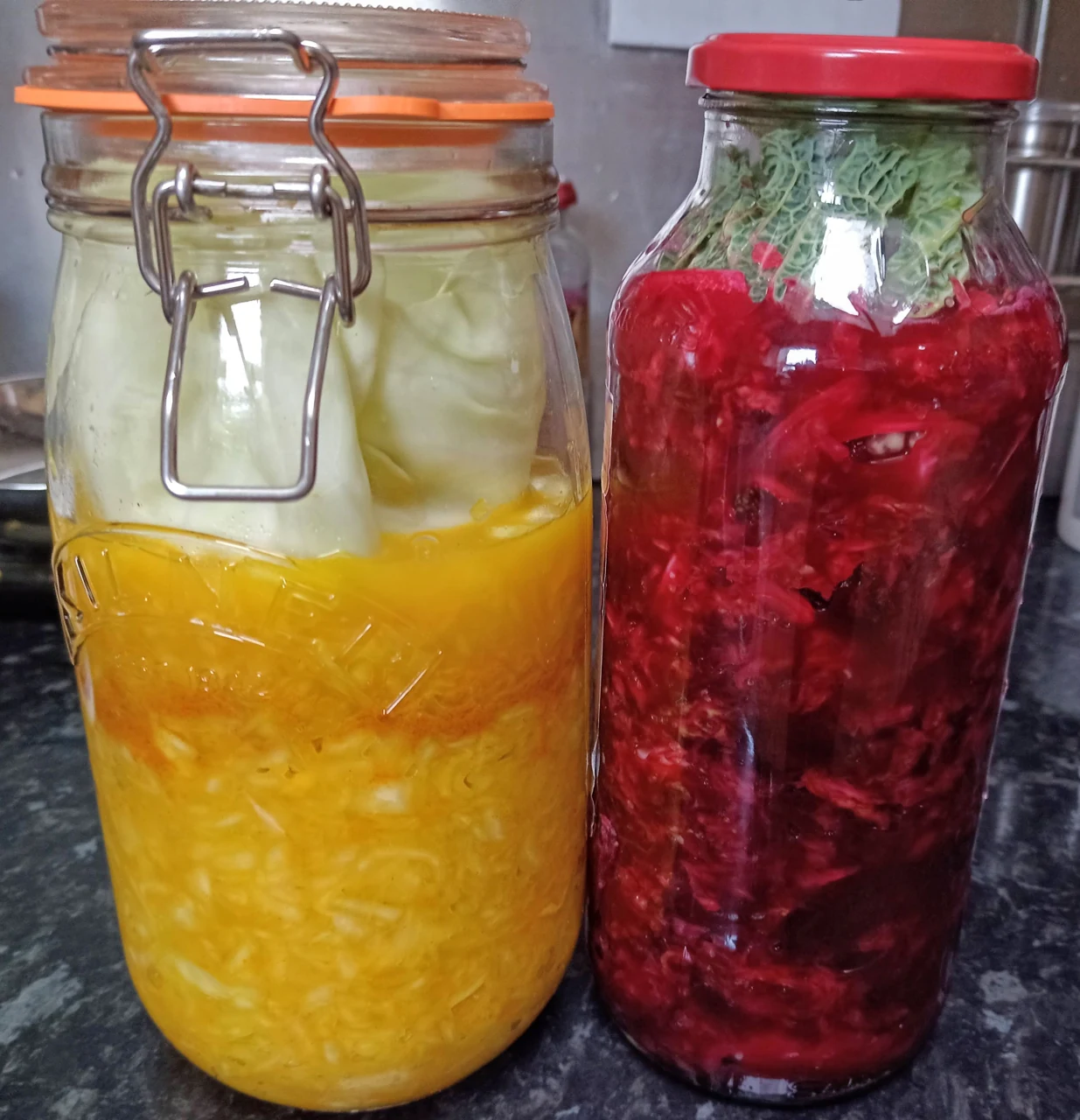 Due vasi di cavolo fermentato con ingredienti e colori differenti