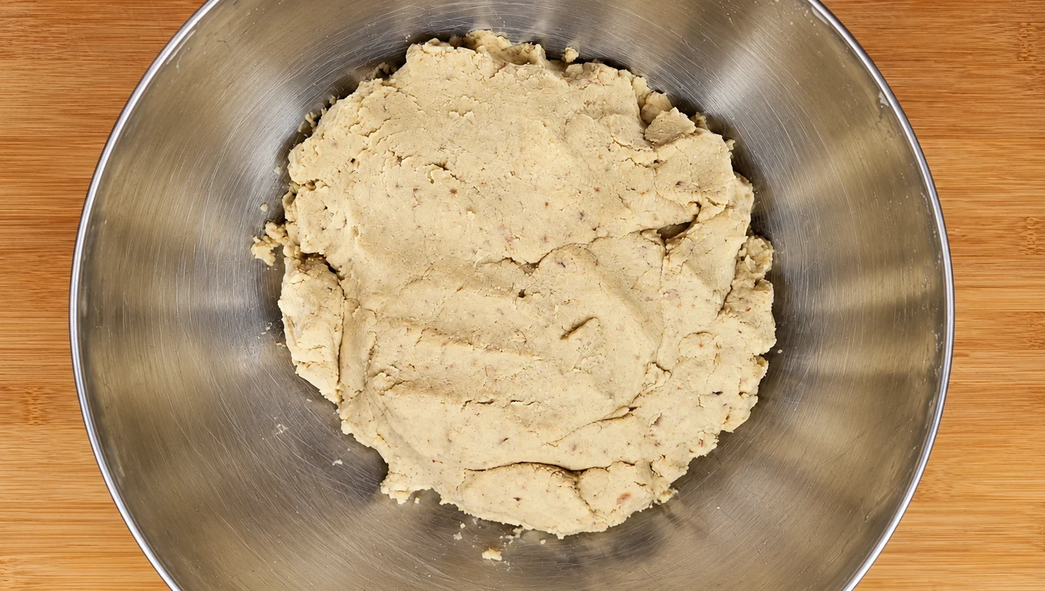 Impasto chiaro di castagne cotte, koji e sale in una ciotola di acciaio prima dell’invasamento