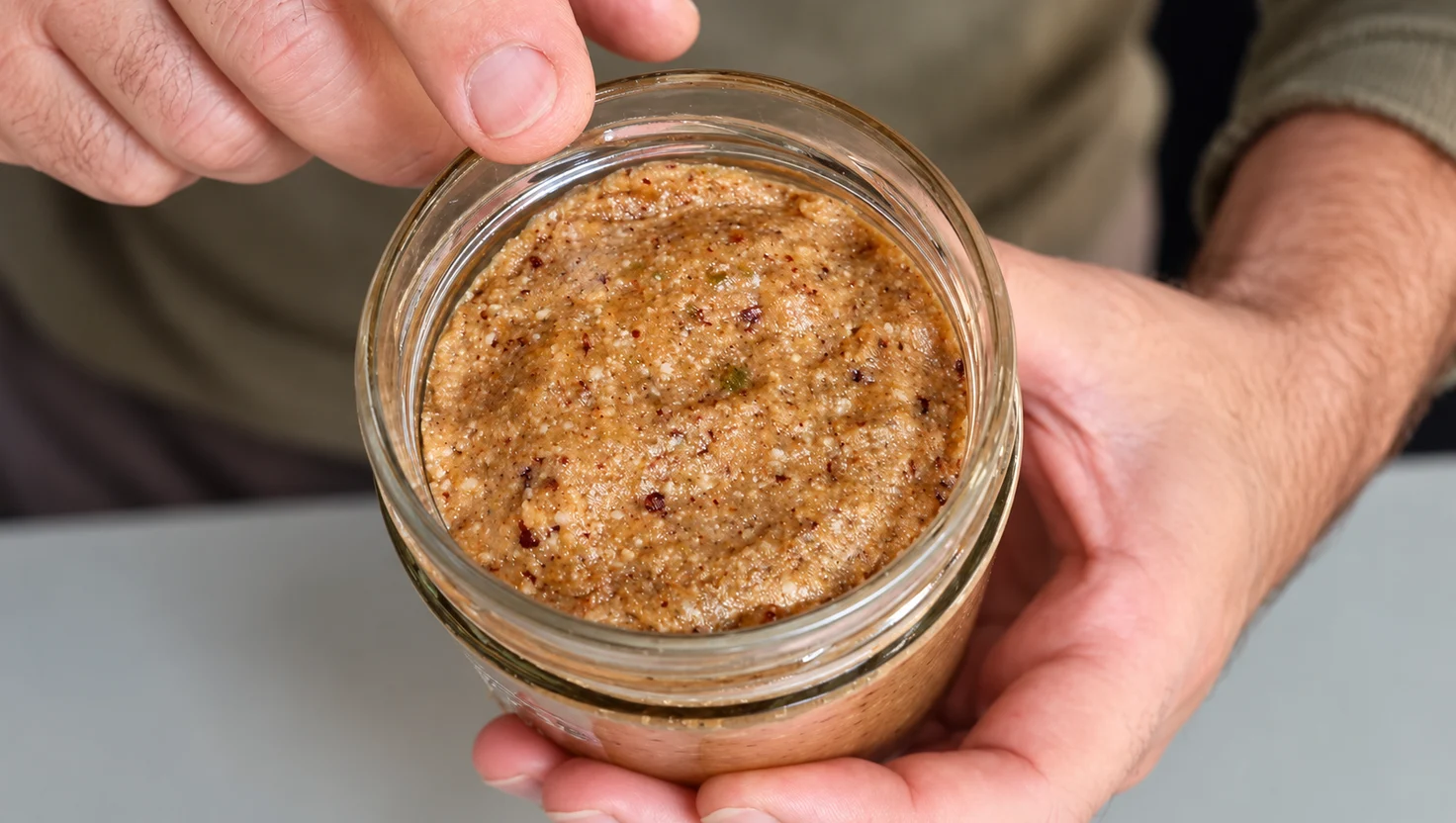 Vaso aperto di miso di castagne dopo un anno di maturazione, tenuto tra le mani da Marco Fortunato