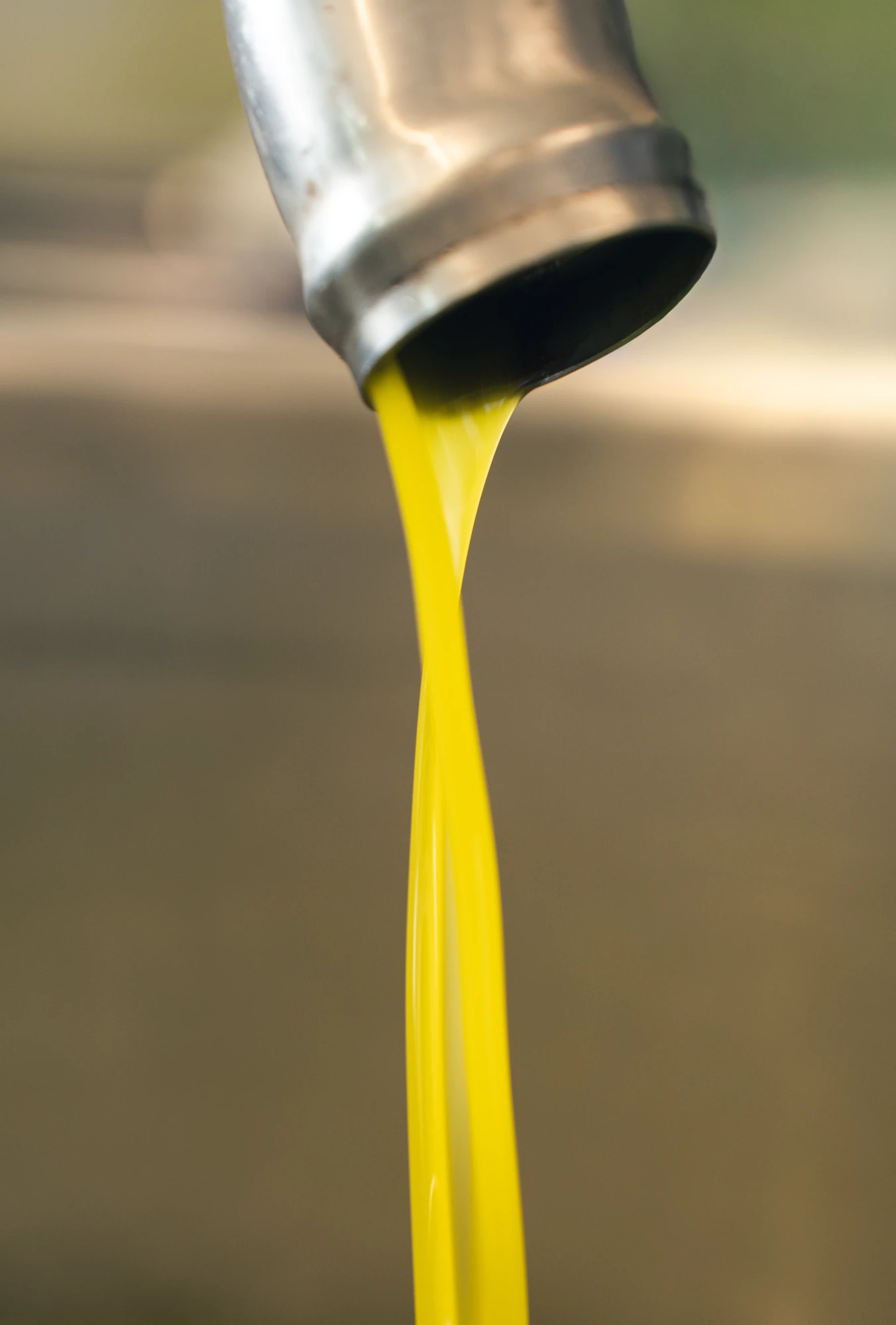 Olio che scende da un macchinario con buco a forma di Parallelepipedo in una grande cisterna/ziro in alluminio Olio che scende da un macchinario con buco a forma di Parallelepipedo in una grande cisterna/ziro in alluminio