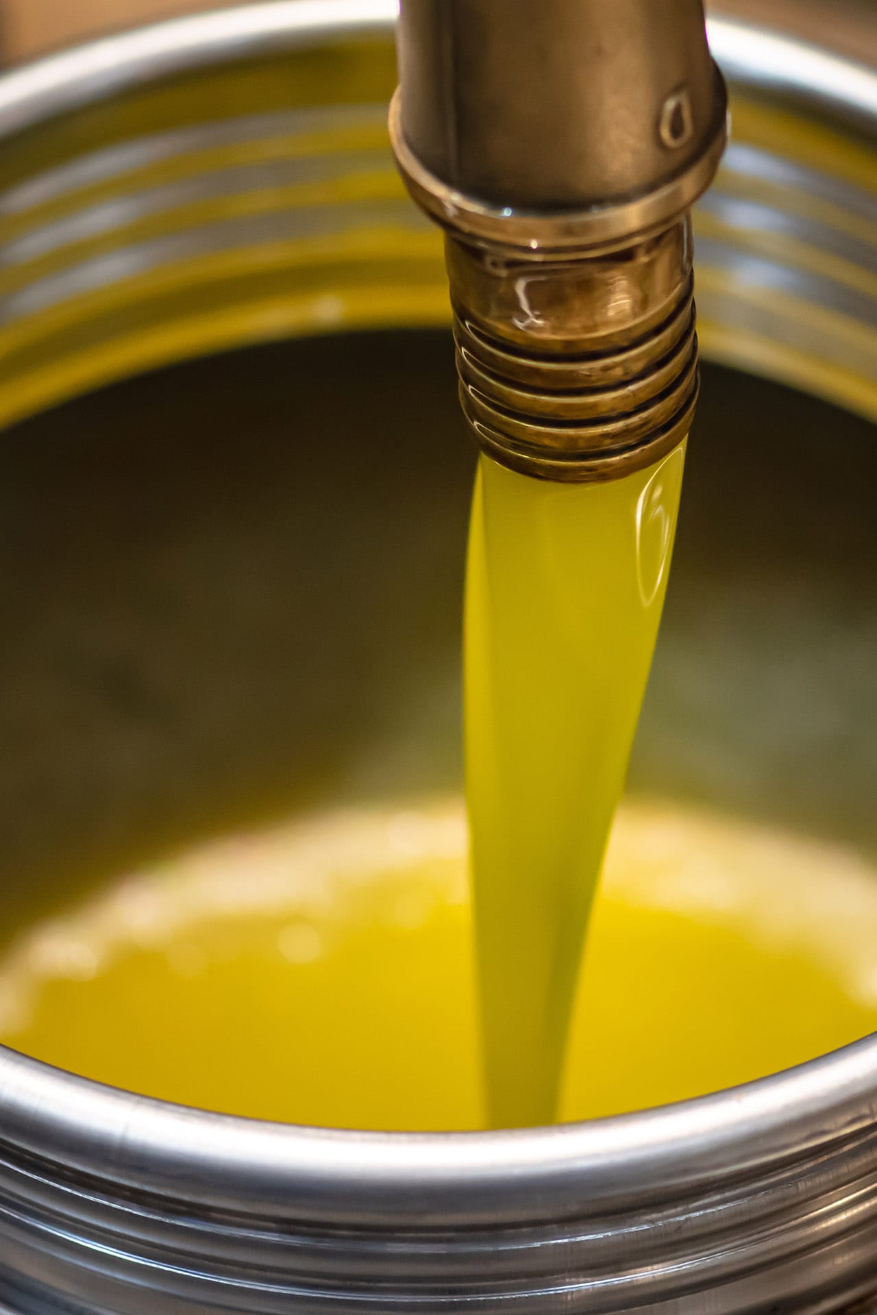 Olio che scende da un macchinario con buco a forma di Parallelepipedo in una grande cisterna/ziro in alluminio Olio che scende da un macchinario con buco a forma di Parallelepipedo in una grande cisterna/ziro in alluminio